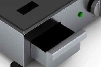 Vista sul vassoio per il grasso in eccesso del barbecue elettrico Flamula, dispositivo moderno per la preparazione dei cibi sulla piastra.