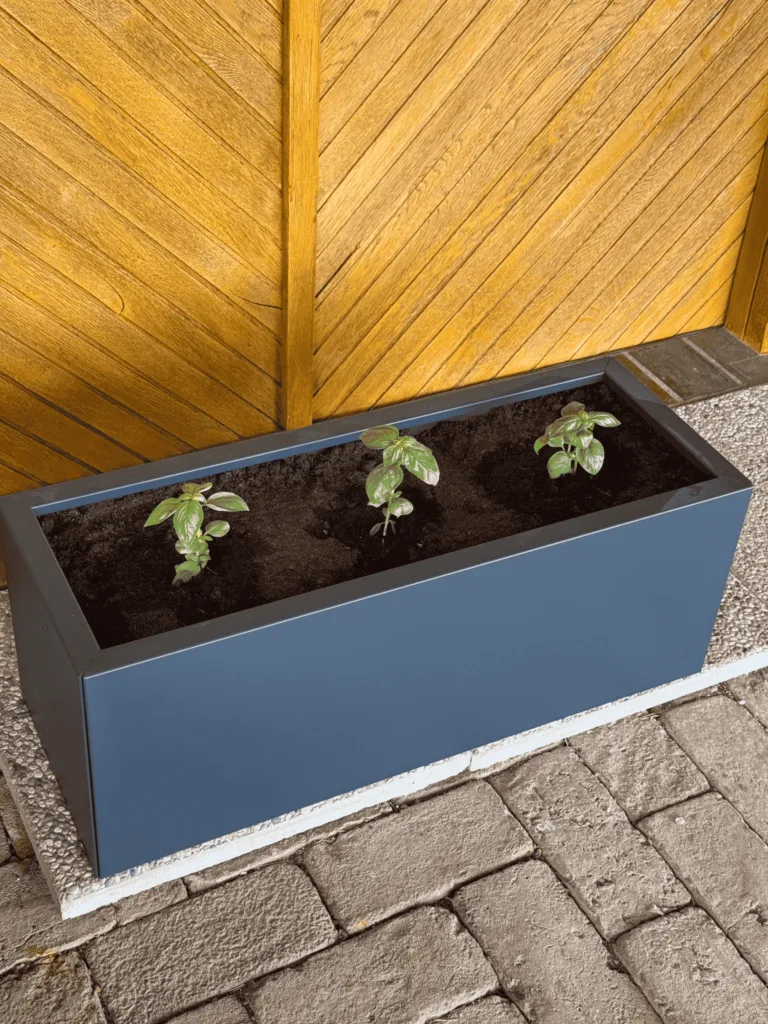 Vaso da fiori metallico con piante piantate sulla terrazza